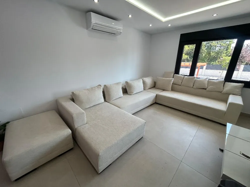 Sofá de tres plazas en tono claro antes del servicio de limpieza profesional de tapicerías a domicilio en Aravaca